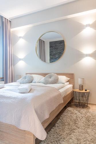 a bedroom with a large bed and a mirror at Aqua Park Residence VIPAPARTAMENTY in Zakopane