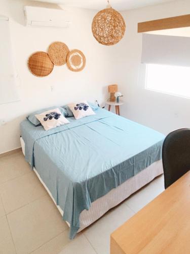 a bedroom with a bed with blue sheets and pillows at Condomínio Vila do Mar - Apartamento 3 quartos in Luis Correia