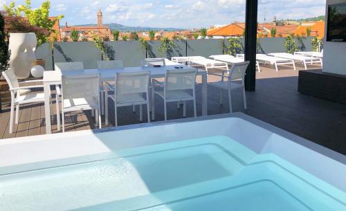 a swimming pool on a roof with a table and chairs at Langhe Panorama in Alba