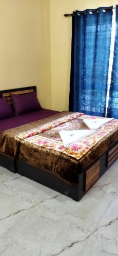 a bed in a room with a blue curtain at Ruby bungalow in Ooty