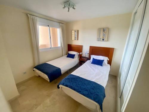 two beds in a small room with a window at Townhouse in Manilva in Manilva