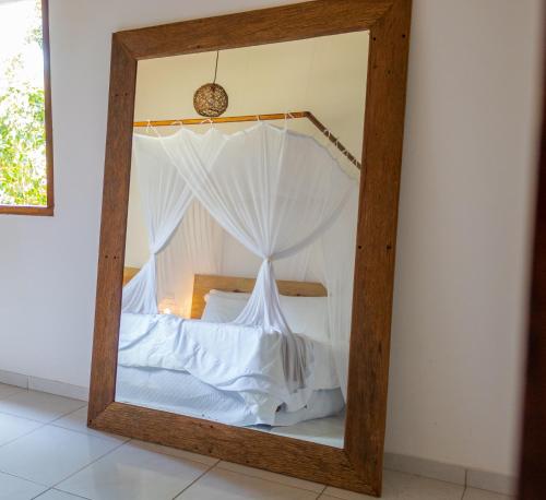 a mirror with a bed in a room at Villa Cacau - Floresta in Trancoso
