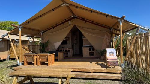 a tent with a wooden deck in front of it at Safari Lodge B in Petten