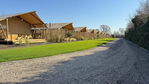 a gravel road next to a row of houses at Safari Lodge B in Petten