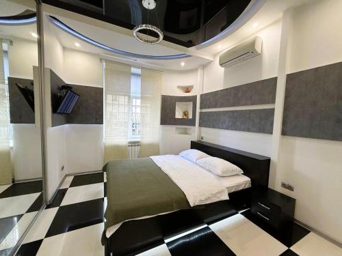 a bedroom with a bed and a black and white checkered floor at Kyiv Kingdom Apartments in Kyiv