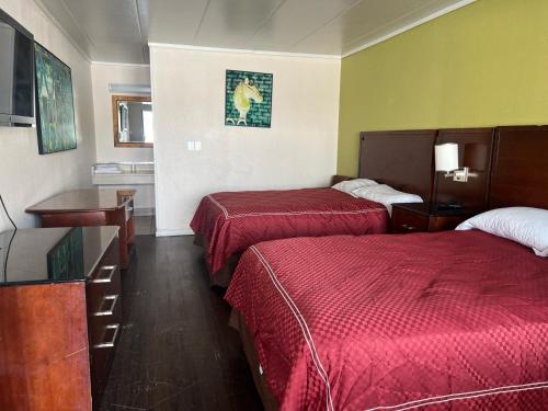 a hotel room with two beds and a television at Capitol Inn by Belvilla Richmond Airport VA in Sandston