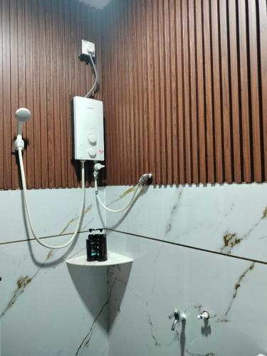 a bathroom with a camera and a hair dryer on the wall at Aahana Homestay in Merlimau