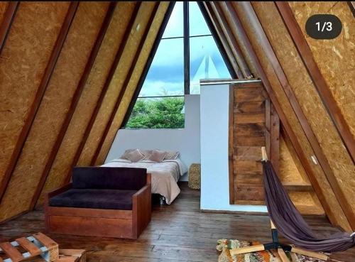 a room with a bed and a chair and a window at El valle Muisca in Guasca