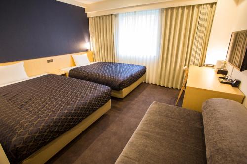 a hotel room with two beds and a window at Hotel Asia Center of Japan in Tokyo
