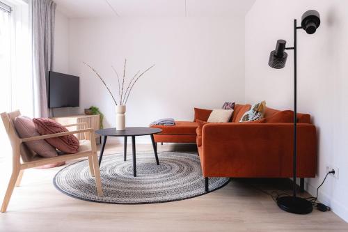 un salon avec un canapé et une table dans l'établissement De Koekoek I Modern en vrijstaand vakantiehuis in het bos, à Nunspeet