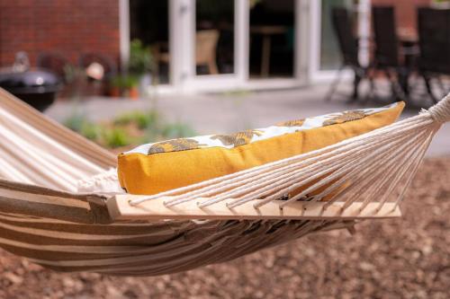 un hamac avec un oreiller dedans dans une cour dans l'établissement De Koekoek I Modern en vrijstaand vakantiehuis in het bos, à Nunspeet