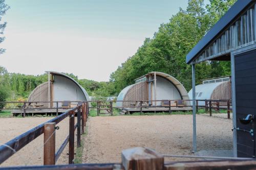 un gruppo di tre cupole con panchine e una recinzione di Paarden lodge a Hoogersmilde