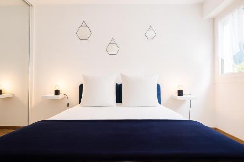 a bedroom with a large bed with a blue blanket at Appartement confortable avec balcon - Proche Gare Riquier SNCF in Nice