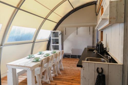 una cucina e una sala da pranzo con tavolo e sedie di Paarden lodge a Hoogersmilde