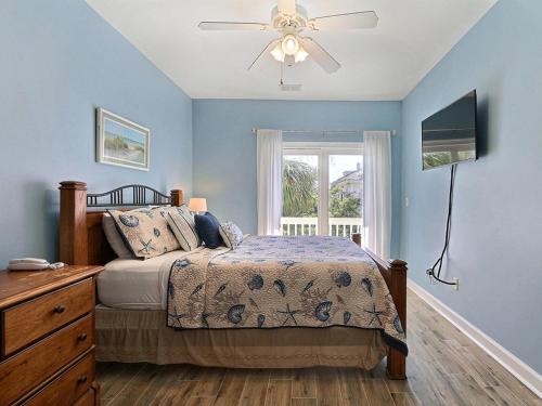 Un dormitorio con una cama y un ventilador de techo. en South Beach Retreat, en Tybee Island