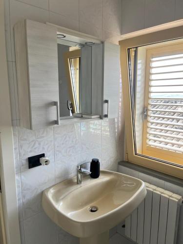 a white bathroom with a sink and a window at Casa Amrita B&B in Teramo