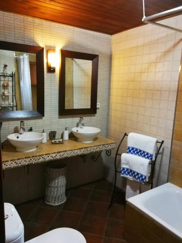 a bathroom with two sinks and two mirrors at Casa Rural Balcón del Camino Viejo in Valencia de Alcántara
