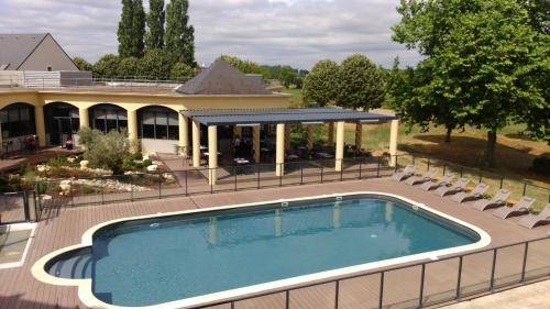 an overhead view of a swimming pool in front of a house at Hotel Le Paddock in Magny-Cours