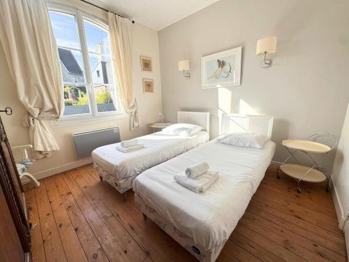 a bedroom with two beds and a window at Le Clos Maréchal in Dinard
