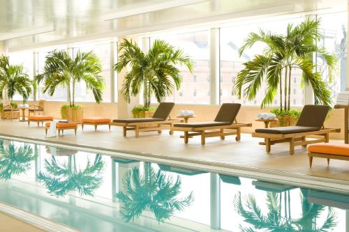 a hotel lobby with a pool and palm trees at Hilton Baltimore Inner Harbor in Baltimore