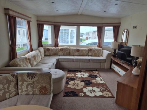a living room with a couch and a tv at Caravan by the Sea 640 in Kinmel Bay