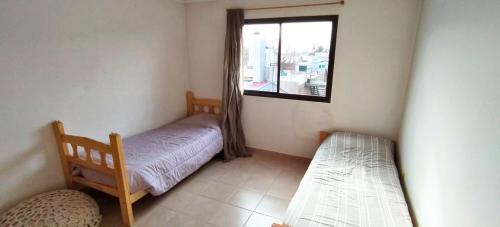 a small room with a bed and a window at Casa Xperience in Malargüe