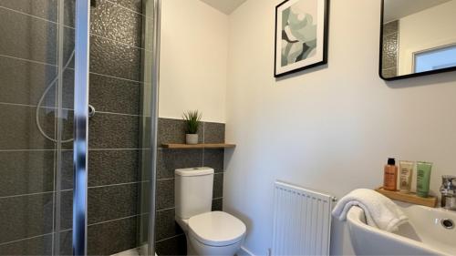 ein Badezimmer mit Dusche, Toilette und Waschbecken in der Unterkunft Newcastle Great Park 4BR Home, Sleeps 8 