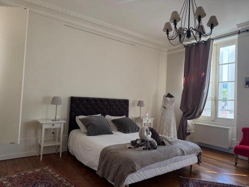 a bedroom with a large bed with a black headboard at Le P'tit Louis in Saint-Cyr-les-Colons