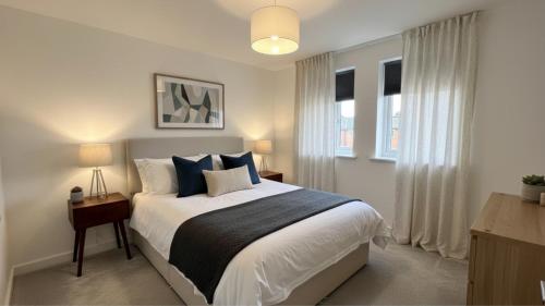 ein Schlafzimmer mit einem großen Bett mit blauen Kissen in der Unterkunft Newcastle Great Park 4BR Home, Sleeps 8 