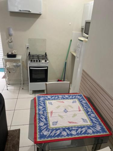 a kitchen with a stove and a table with a rug at Albuquerque nro36 casa 5 in Campinas