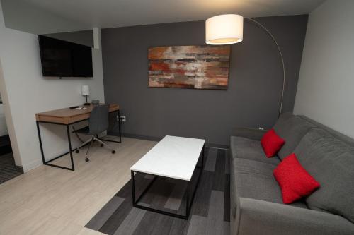 a living room with a couch and a table and a desk at University Guest House and Conference Center in Salt Lake City