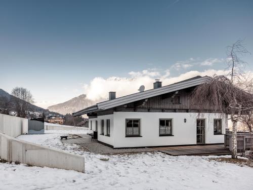 a white house in the snow with mountains in the background at Chalet Pirchhof inklusive Sauna in Sautens