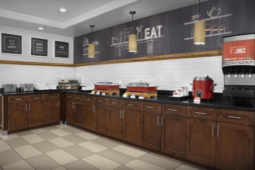 Una cocina de restaurante con gabinetes de madera y encimera. en Hampton Inn & Suites Ocean City Bayfront-Convention Center, en Ocean City