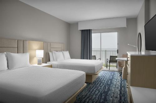 a hotel room with two beds and a balcony at Hampton Inn & Suites Ocean City Bayfront-Convention Center in Ocean City