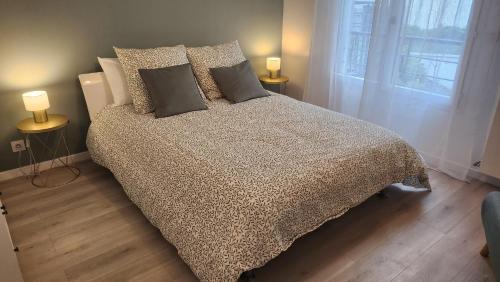 a bedroom with a bed with pillows and a window at Élégance et charme aux portes de Paris in Saint-Ouen