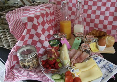 een picknicktafel met een bord eten en fruit bij De Oude Koeienstal in Schimmert