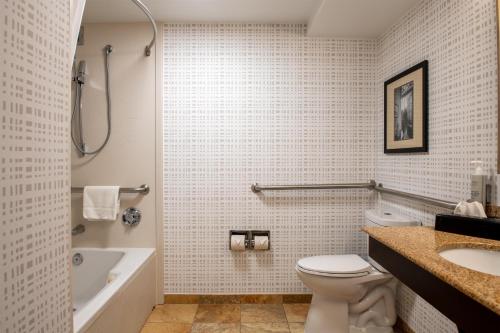 a bathroom with a toilet and a tub and a sink at Hampton Inn Portsmouth Central in Portsmouth