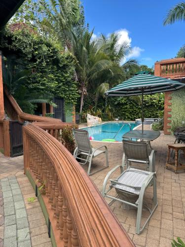 a patio with chairs and an umbrella next to a pool at Hidden oasis in Mandeville
