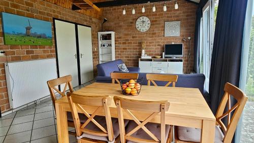 Boerenslag 44 في سينت مارتنسي: غرفة طعام مع طاولة وكراسي خشبية