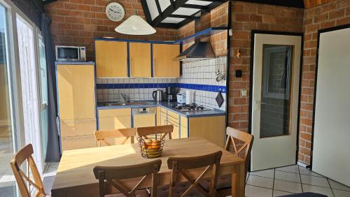 Boerenslag 44 في سينت مارتنسي: مطبخ مع طاولة وكراسي خشبية