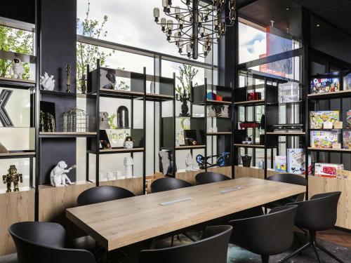 Un comedor con mesa y sillas de madera. en Aparthotel Adagio access Palaiseau Saclay, en Palaiseau