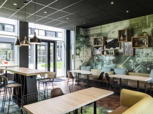 Un restaurante con mesas y sillas en una habitación. en Aparthotel Adagio access Palaiseau Saclay, en Palaiseau
