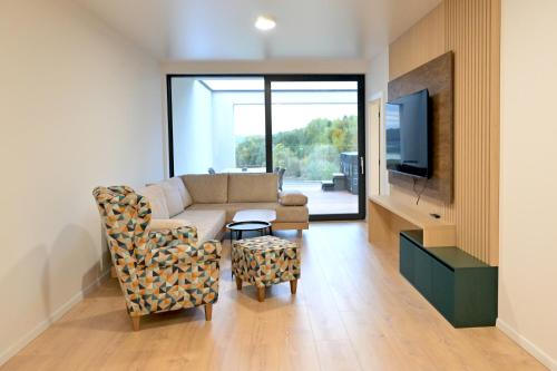 a living room with a couch and a tv at Quantara Resort Domaša in Holčíkovce