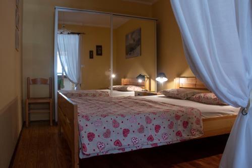 a bedroom with two beds and a mirror at Case Gran Paradiso Rhemes Notre Dame Piazza in Rhêmes-Notre-Dame