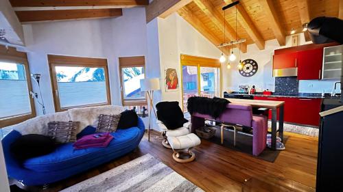 a living room with a blue couch and a table at Mon Rêve Bijou in Bettmeralp