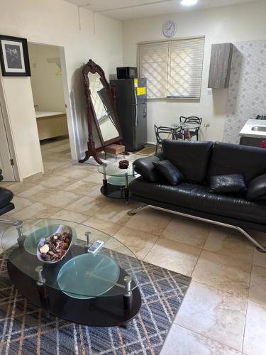 a living room with a black couch and a glass table at Hidden oasis in Mandeville