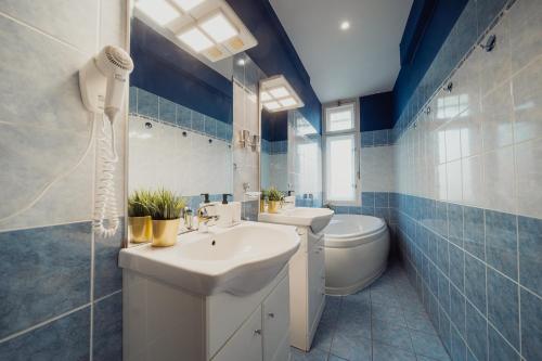 a blue and white bathroom with a sink and a toilet at Waterfront River Side Roof Top Apartment - Terrace with city view in Prague