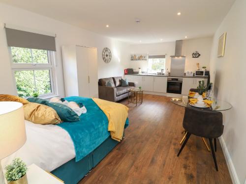 a bedroom with a bed and a table and a kitchen at Four in Peterborough