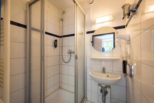a bathroom with a shower and a sink at a&o Berlin Mitte in Berlin