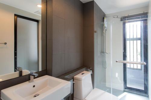 W łazience znajduje się umywalka, toaleta i prysznic. w obiekcie 6th Avenue Surin Beach w mieście Surin Beach